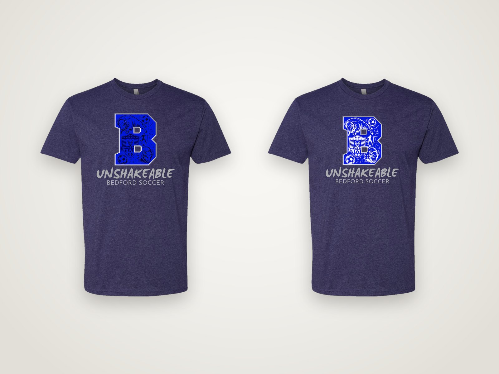 Two heather navy Bedford Soccer tees with a large blue B and the word Unshakeable